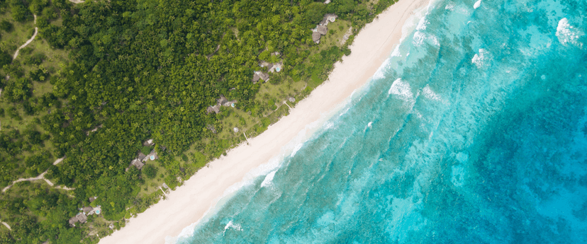 Arrive by helicopter — the activity/scene in action. The signature fifteen-minute flight from Mahé.