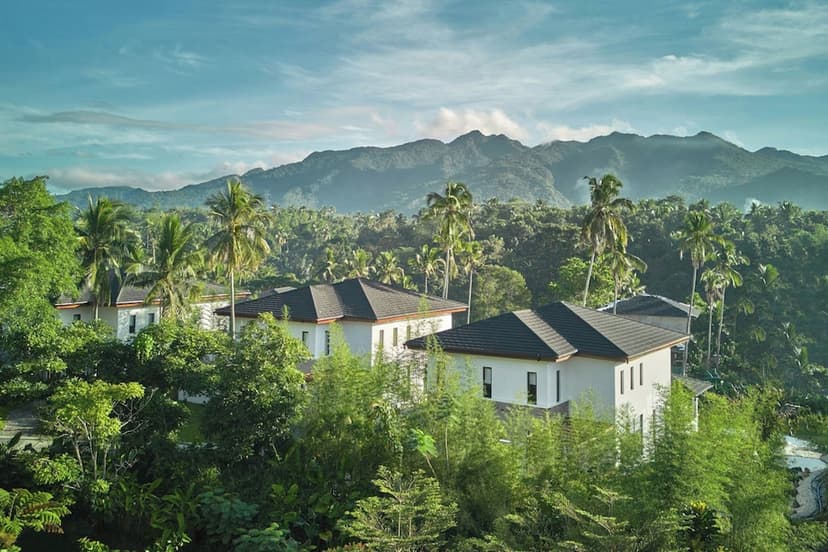 Hero/establishing shot of The Farm at San Benito, Batangas, Philippines. The Philippines’ flagship holistic wellness and medical retreat — around 90 minutes south of Manila in the coconut-plantation forest of Lipa, Batangas, with Malarayat 
