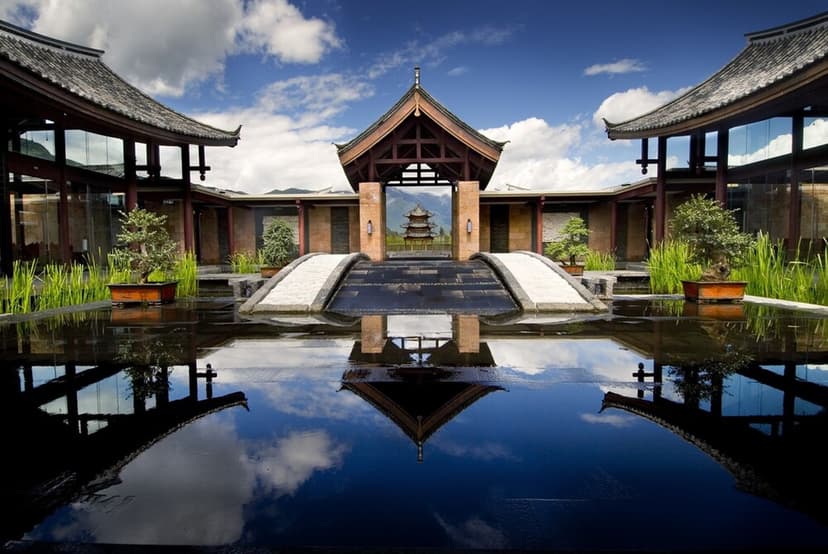 Hero/establishing shot of Banyan Tree Lijiang, Lijiang, China. A Naxi-style villa resort at around 2,000 metres just south of the sacred Jade Dragon Snow Mountain in Yunnan — every villa faces the peak.