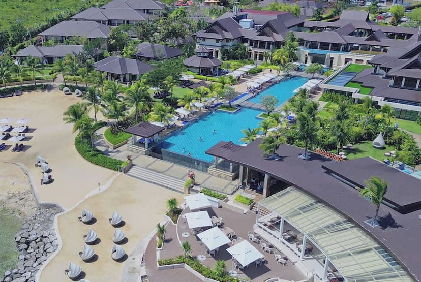 Hero/establishing shot of Crimson Resort and Spa Mactan, Cebu, Cebu, Philippines. A Balinese-inspired beach resort on Mactan with a private beach cove and a three-tiered infinity pool over the Cebu Strait — the most accessible of the Philip
