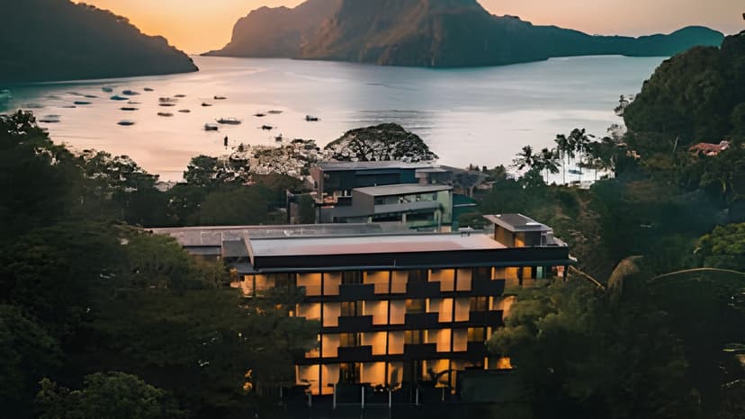 Hero/establishing shot of El Nido Resorts Pangulasian Island, El Nido, Philippines. An eco-luxury private island in Bacuit Bay — the ‘Island of the Sun’, catching both sunrise and sunset — fronting a 750-metre white-sand beach with a marine