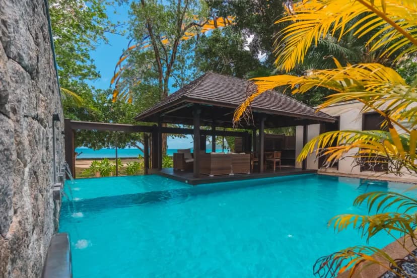Signature hero of STORY Seychelles (Beau Vallon, Mahé, Seychelles): the single most iconic wide view — Beau Vallon Beach, Design-led, Near Victoria. Golden-hour, landscape, room to overlay text.