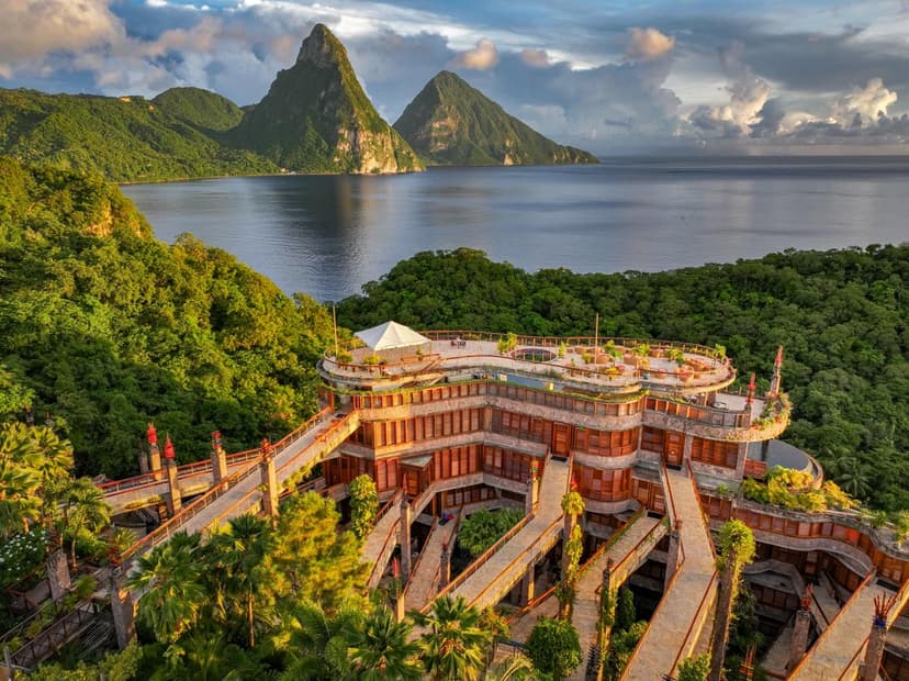 Hero/establishing shot of Jade Mountain, St Lucia. The Caribbean's most iconic room design: open-fourth-wall sanctuaries with private infinity pools framing the Pitons, perched on a cliff above sister resort Anse Chastanet.