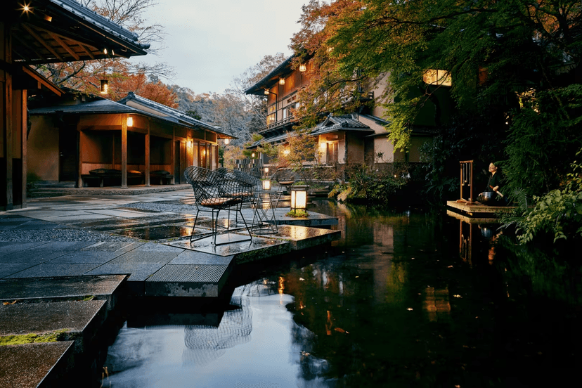 Hero/establishing shot of HOSHINOYA Kyoto, Kyoto, Japan. A luxury ryokan reached only by private houseboat up the Ōi River into an Arashiyama gorge — a 400-year-old Heian noble-retreat site, restored across century-old cedar buildings.