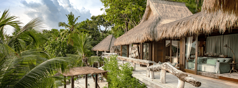 Signature hero of North Island (Private Island, Seychelles): the single most iconic wide view — Private island, Eleven villas only, Helicopter arrival. Golden-hour, landscape, room to overlay text.