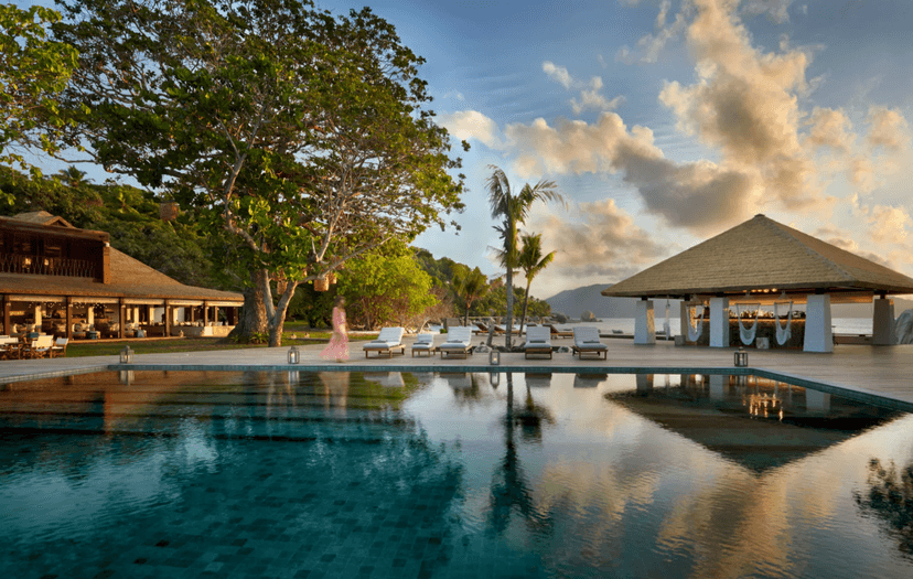 Signature hero of Six Senses Zil Pasyon (Félicité Island, Seychelles): the single most iconic wide view — Private island, Boulder-top spa, Wellness-led. Golden-hour, landscape, room to overlay text.