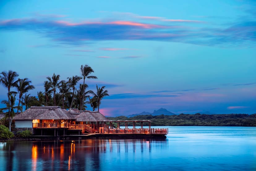 Signature hero of One&Only Le Saint Géran (East Coast, Mauritius): the single most iconic wide view — Grande dame, Private peninsula, Ultra-luxury. Golden-hour, landscape, room to overlay text.