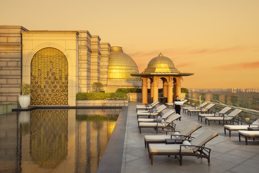 Hero/establishing shot of The Leela Palace New Delhi, New Delhi, India. A modern Lutyens-style palace in New Delhi’s Diplomatic Enclave — golden domes floodlit at night, gold leaf and museum-grade Indian art.