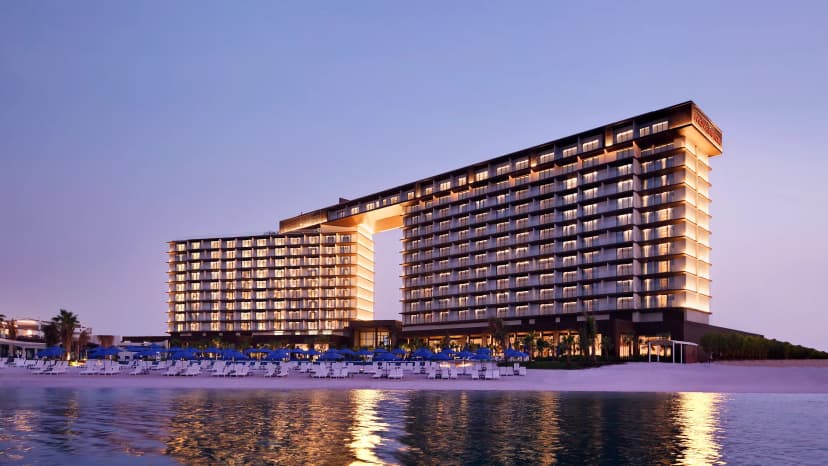 Hero/establishing shot of Mövenpick Resort Al Marjan Island, Ras Al Khaimah. A Swiss-hospitality family beachfront resort on Al Marjan Island, with 418 sea-view rooms plus 28 beachfront chalets with private pools.