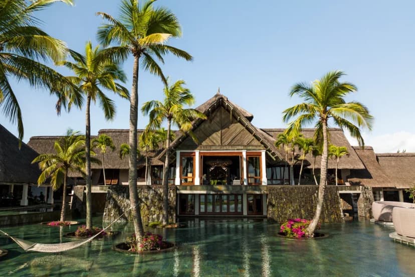 Signature hero of Constance Prince Maurice (East Coast, Mauritius): the single most iconic wide view — Intimate ultra-luxury, Stilted lagoon suites, Floating restaurant. Golden-hour, landscape, room to overlay text.