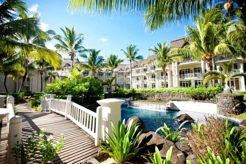 Signature hero of LUX* Belle Mare (East Coast, Mauritius): the single most iconic wide view — Playful five-star, All-inclusive option, Design-led. Golden-hour, landscape, room to overlay text.