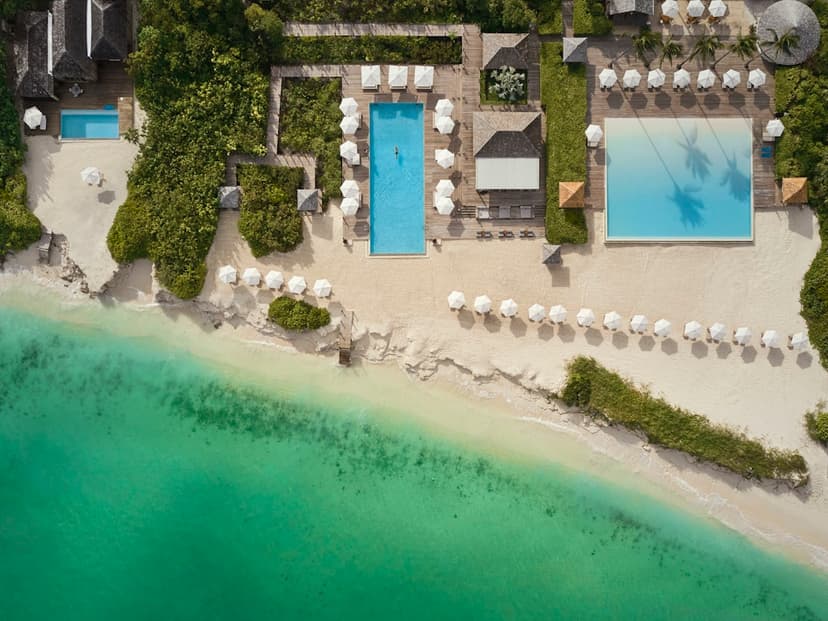 Hero/establishing shot of COMO Parrot Cay, Turks & Caicos. A private thousand-acre island reached by COMO's own boat launch, home to the multi-award-winning COMO Shambhala wellness retreat — the Caribbean's pre-eminent wellness destination.