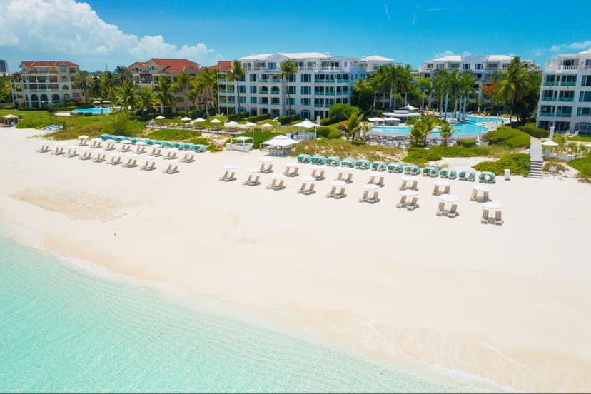 Hero/establishing shot of The Palms Turks and Caicos, Providenciales, Turks & Caicos. An iconic, recently refreshed Grace Bay all-suite resort, with the famous serpentine infinity pool and its kid-friendly baja shelf and swim-up bar.